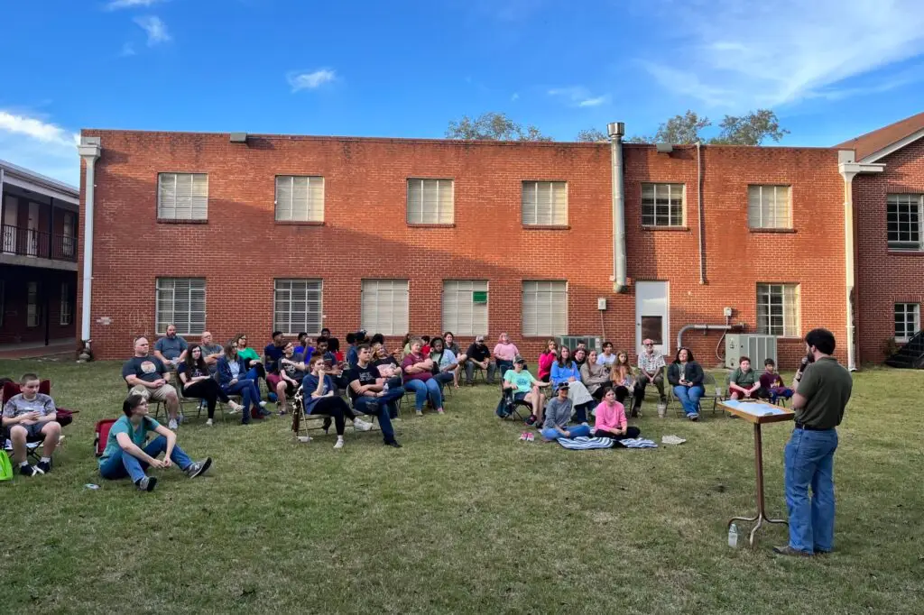 Bro. Mitchell Herron teaching Dalraida students outside in the grass