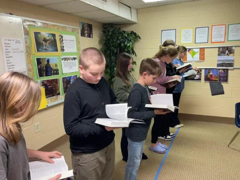 Kids flipping through their Bibles as they participate in Bible Drill