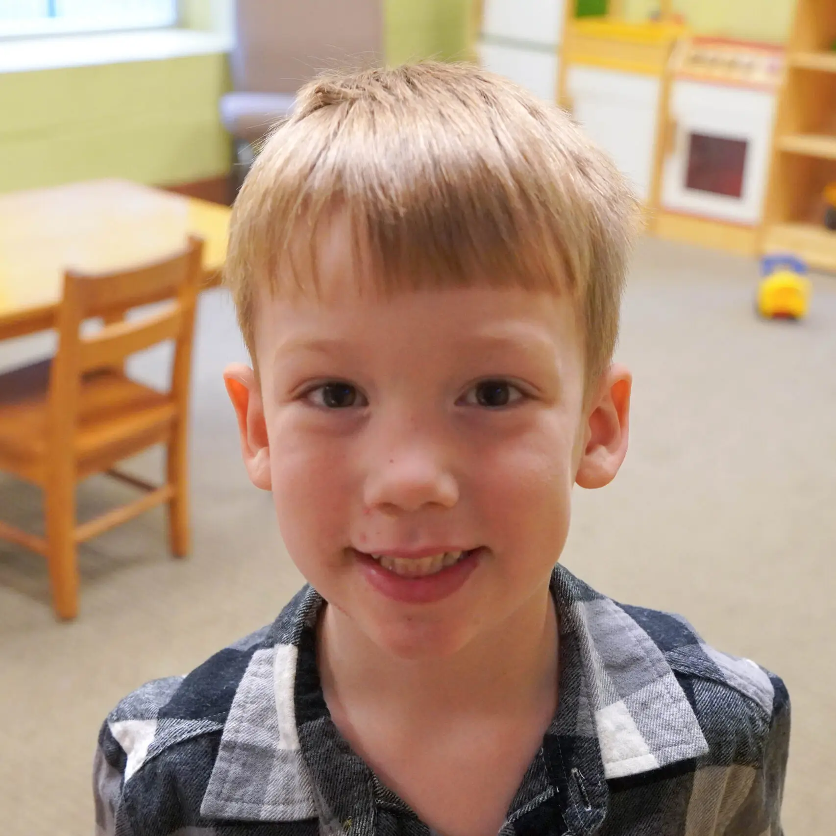 Little boy with blonde hair and a blue and white plaid shirt