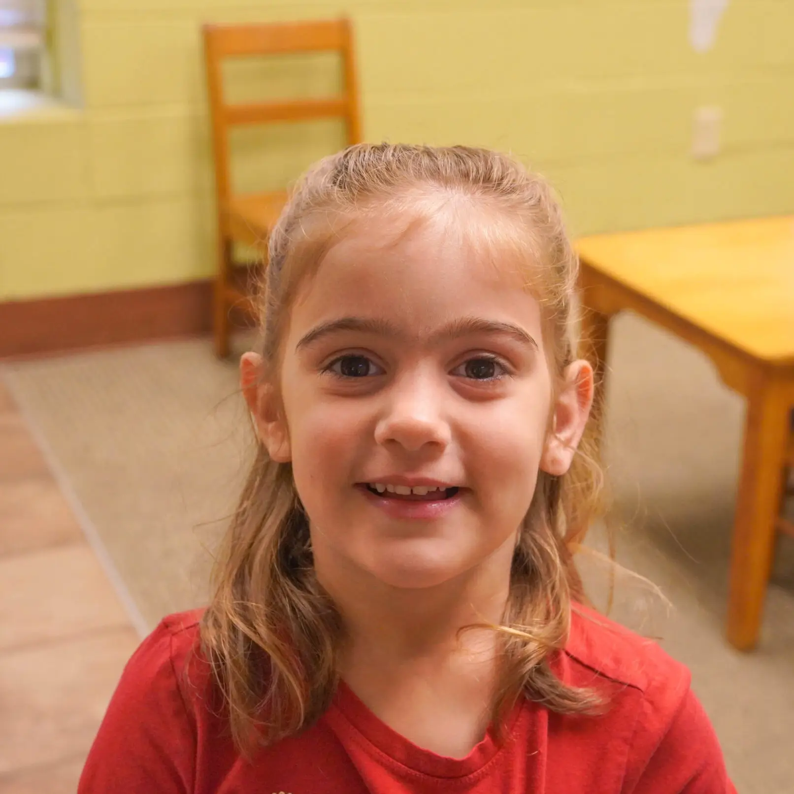 Little girl with brown hair and red shirt