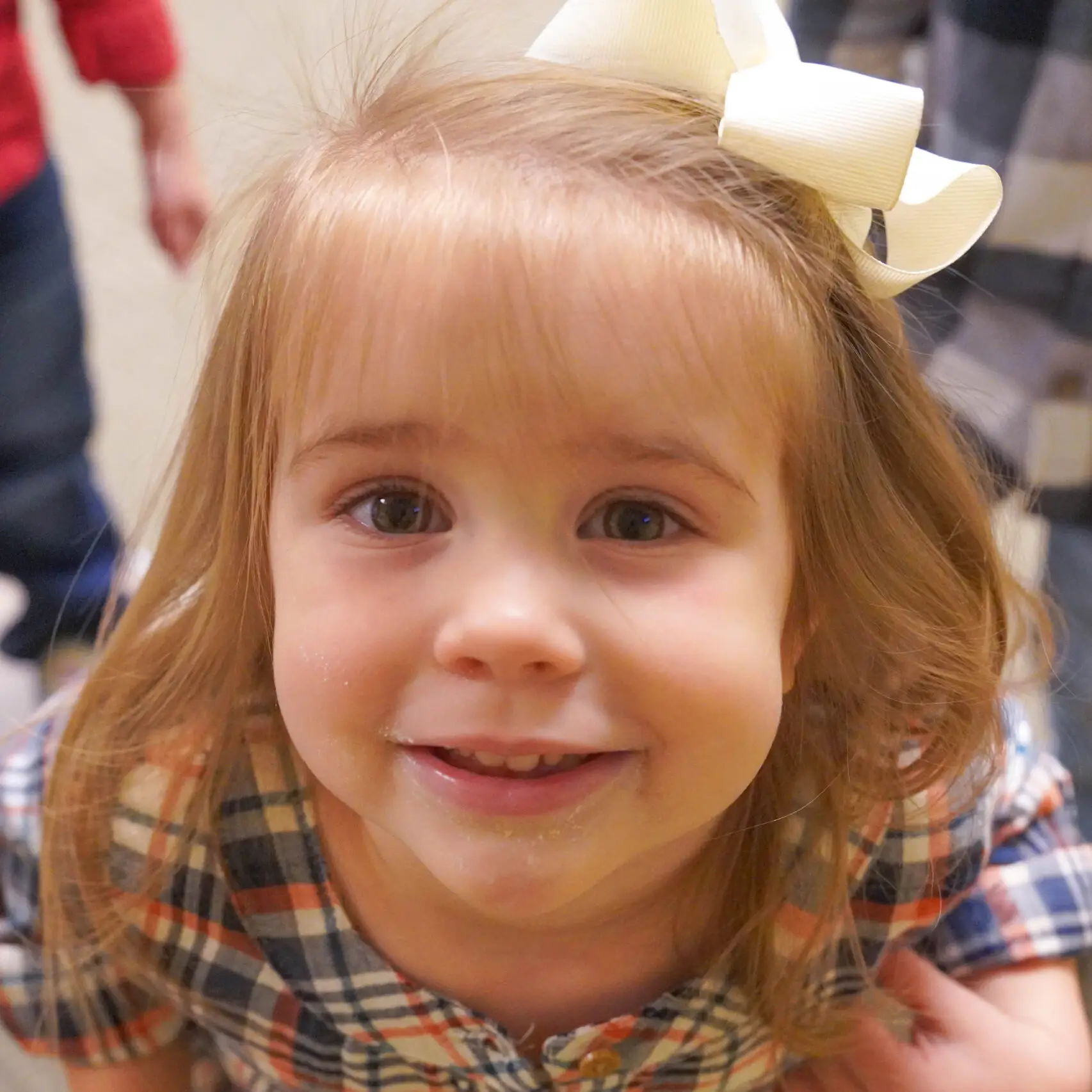 Little girl with light brown hair and bow in her hair