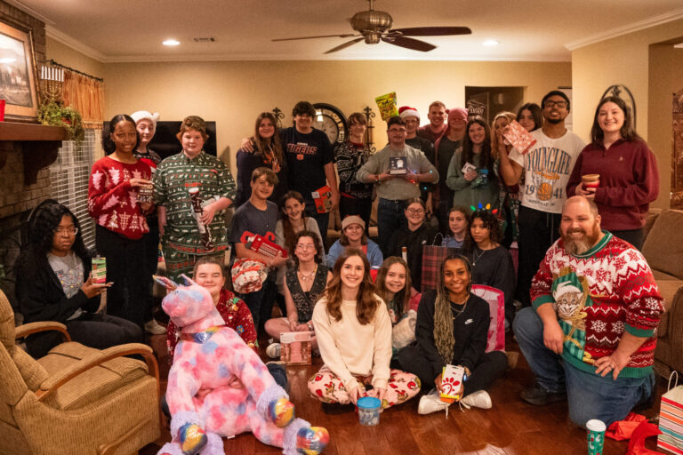 A large group of students pose during their Christmas party in ugly sweaters